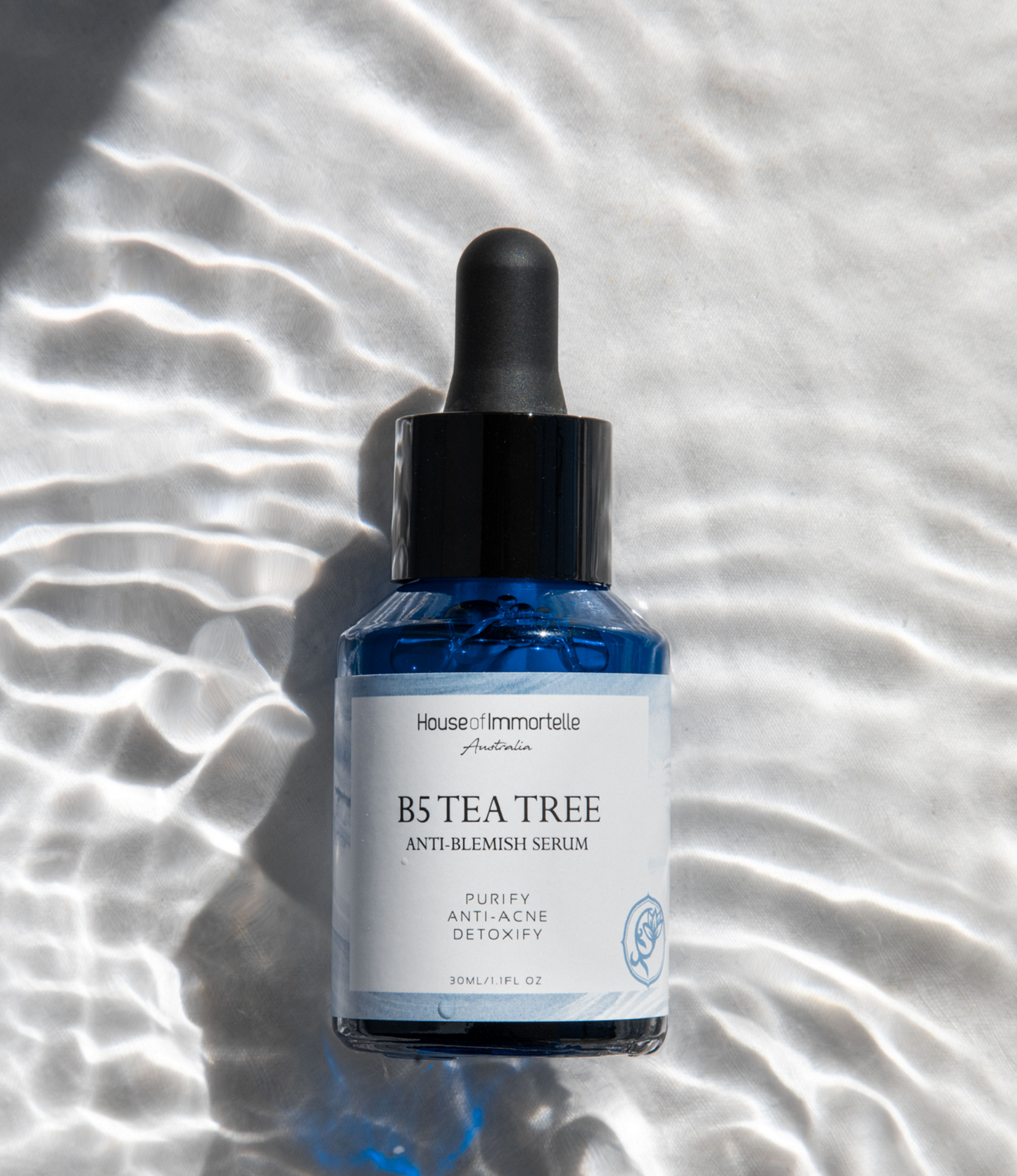 House of Immortelle B5 Tea Tree Anti-Blemish Serum in a sleek bottle, formulated with tea tree oil and vitamin B5 to target blemishes and soothe the skin. This lightweight serum helps reduce the appearance of acne and blemishes, leaving the skin clear and balanced