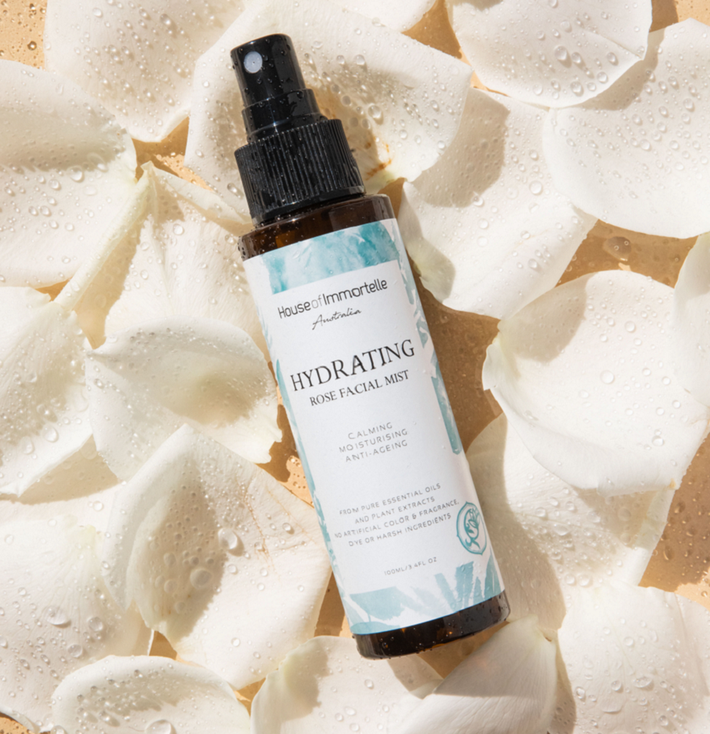 House of Immortelle Hydrating Rose Facial Mist in a sleek spray bottle, infused with rose extract to refresh and hydrate the skin. This mist provides a soothing, dewy glow, perfect for revitalizing the skin throughout the day or setting makeup