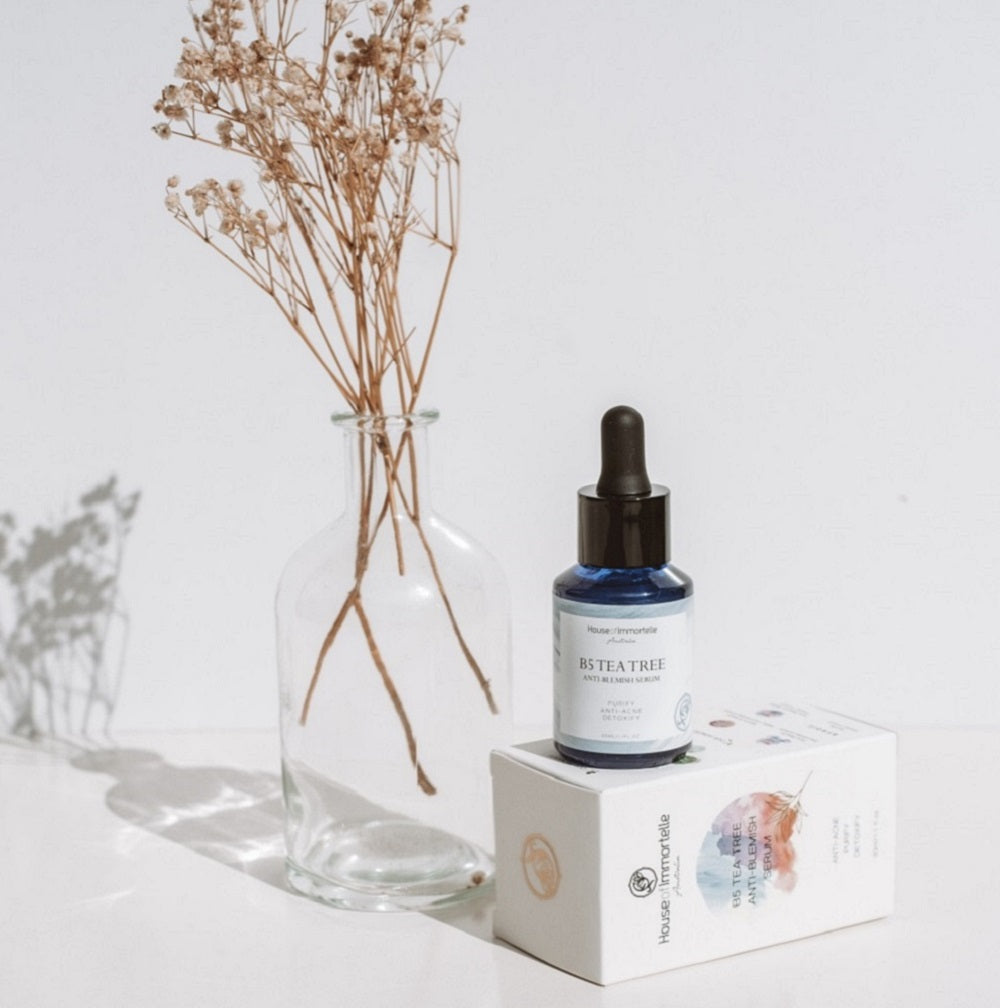 House of Immortelle B5 Tea Tree Anti-Blemish Serum in a sleek bottle, formulated with tea tree oil and vitamin B5 to target blemishes and soothe the skin. This lightweight serum helps reduce the appearance of acne and blemishes, leaving the skin clear and balanced