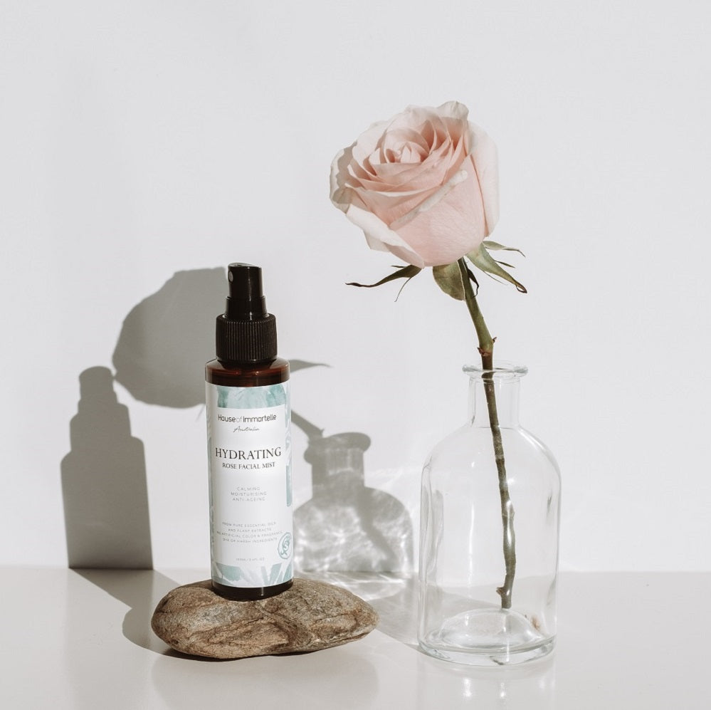 House of Immortelle Hydrating Rose Facial Mist in a sleek spray bottle, infused with rose extract to refresh and hydrate the skin. This mist provides a soothing, dewy glow, perfect for revitalizing the skin throughout the day or setting makeup