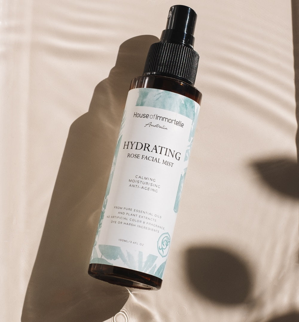 House of Immortelle Hydrating Rose Facial Mist in a sleek spray bottle, infused with rose extract to refresh and hydrate the skin. This mist provides a soothing, dewy glow, perfect for revitalizing the skin throughout the day or setting makeup