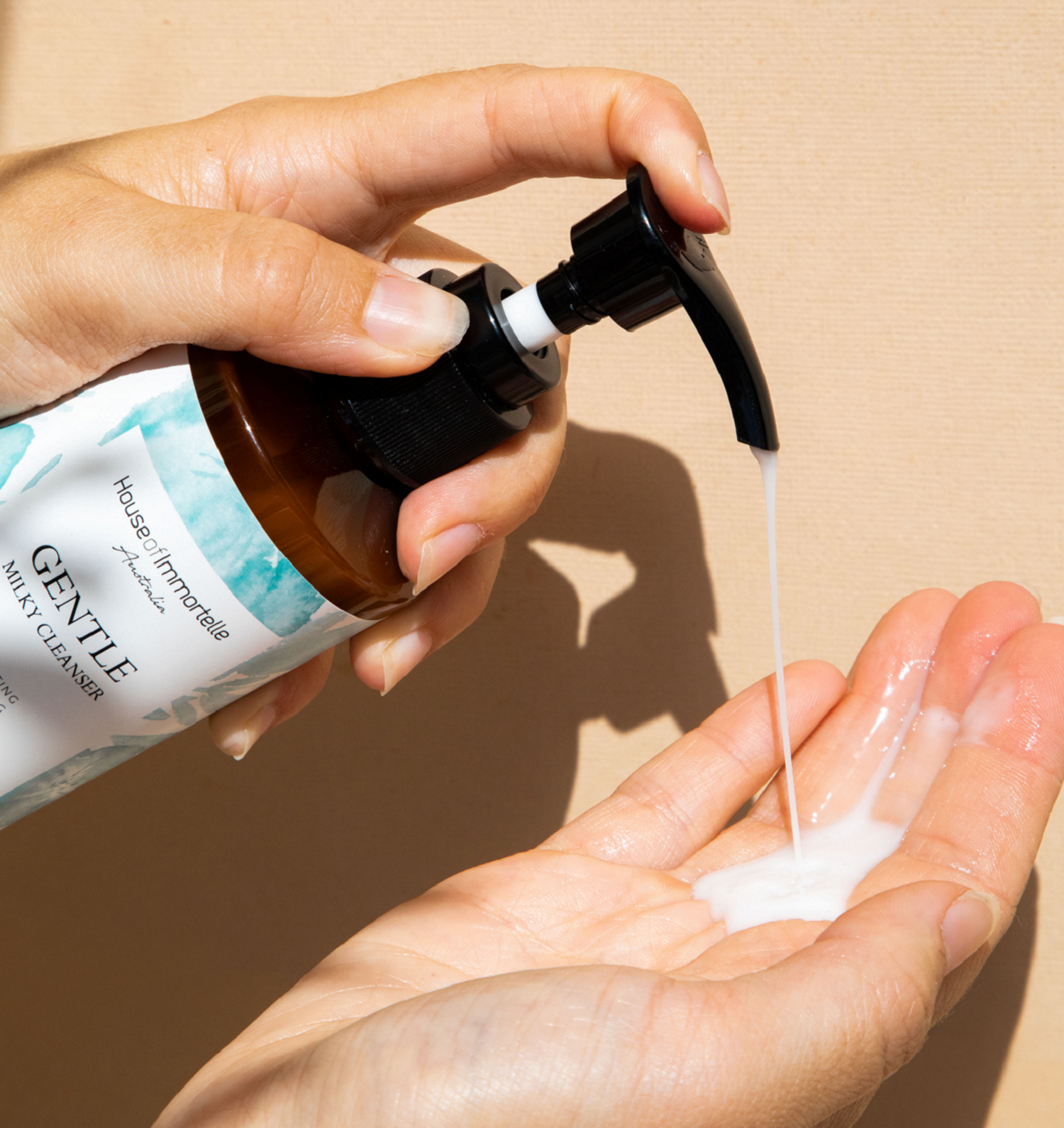 House of Immortelle Gentle Milky Cleanser in a smooth bottle, featuring a creamy formula designed to cleanse and hydrate the skin. This mild cleanser gently removes impurities while nourishing, leaving the skin soft, refreshed, and balanced