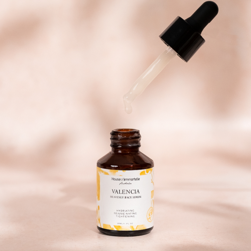 House of Immortelle Valencia Heavenly Face Serum in a sleek, elegant bottle, featuring a lightweight formula designed to hydrate and nourish the skin. The serum is infused with natural ingredients, offering a glowing, refreshed complexion, and is ideal for daily skincare routines