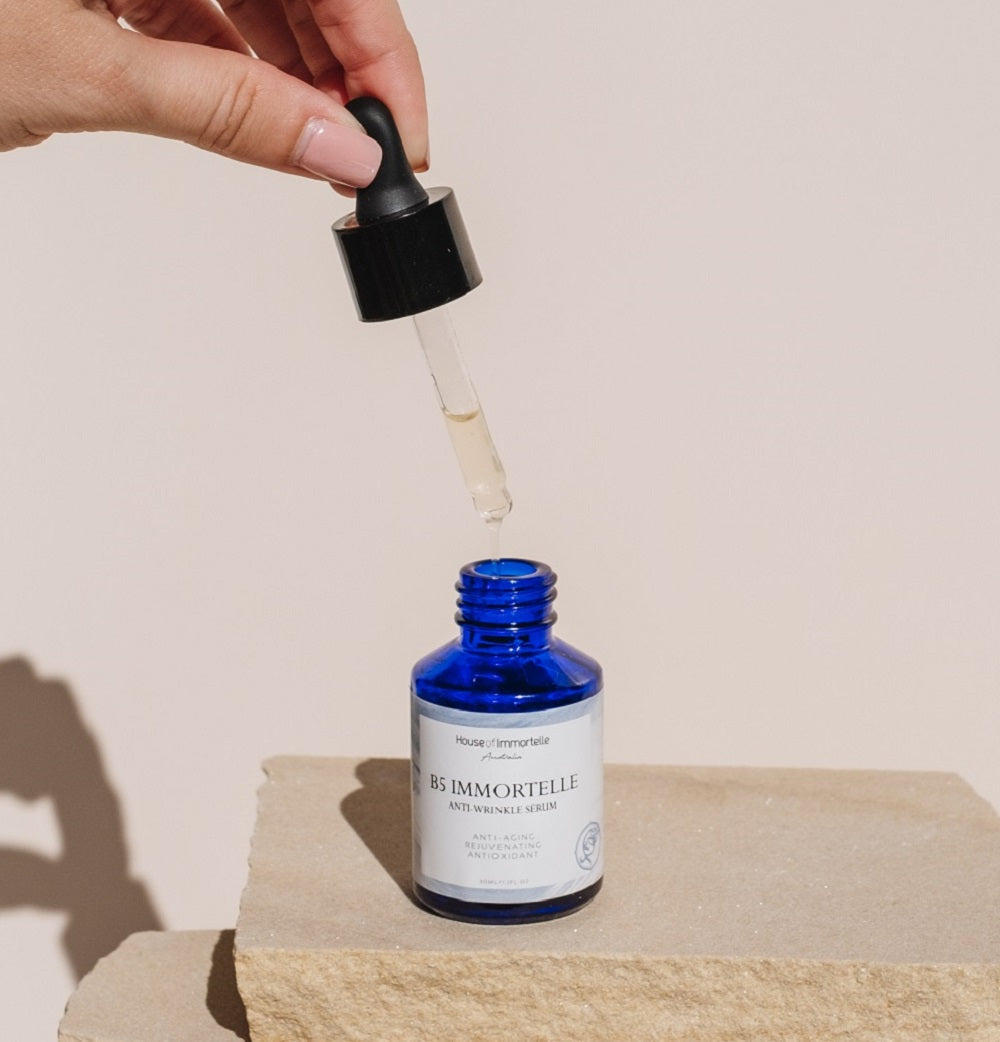 House of Immortelle B5 Immortelle Anti-Wrinkle Serum in an elegant bottle, enriched with Immortelle flower extract and vitamin B5 to reduce the appearance of fine lines and wrinkles. This lightweight serum helps to smooth, hydrate, and rejuvenate the skin for a more youthful complexion