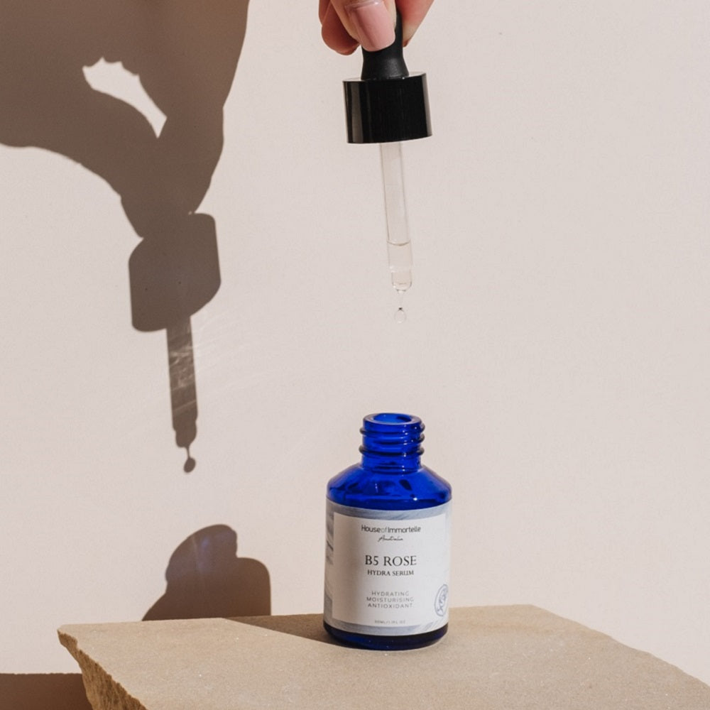 House of Immortelle B5 Rose Hydra Serum bottle with a sleek design and dropper cap. The serum is designed to deeply hydrate and soothe the skin, enriched with Vitamin B5 and rose extracts for a refreshed and radiant complexion