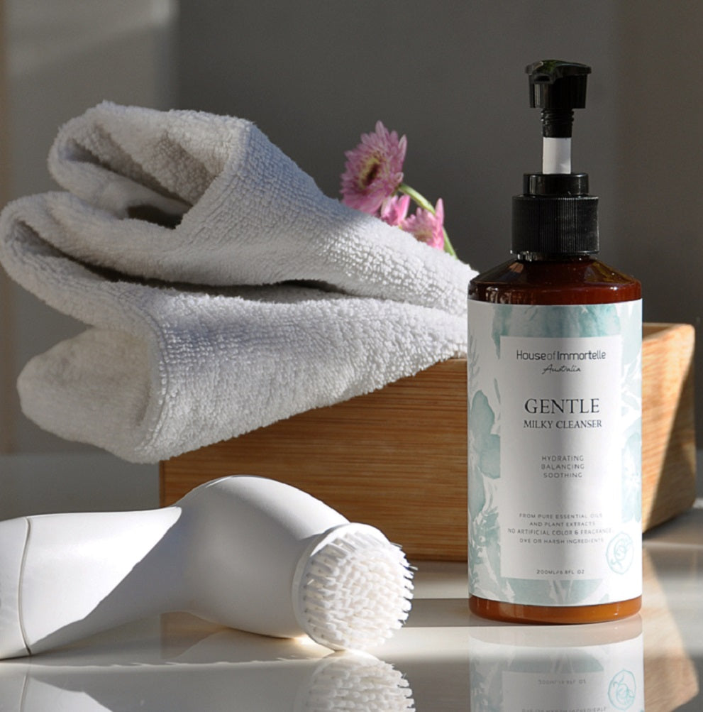 House of Immortelle Gentle Milky Cleanser in a smooth bottle, featuring a creamy formula designed to cleanse and hydrate the skin. This mild cleanser gently removes impurities while nourishing, leaving the skin soft, refreshed, and balanced