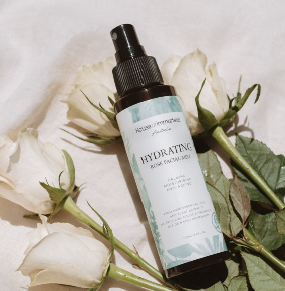 House of Immortelle Hydrating Rose Facial Mist in a sleek spray bottle, infused with rose extract to refresh and hydrate the skin. This mist provides a soothing, dewy glow, perfect for revitalizing the skin throughout the day or setting makeup