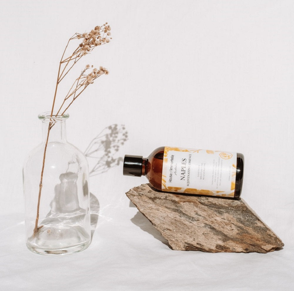 House of Immortelle Naples Rejuvenating Essence in an elegant bottle, designed to hydrate and revitalize the skin. Infused with nourishing ingredients, this essence promotes a smoother, more youthful complexion, giving the skin a refreshed and rejuvenated appearance