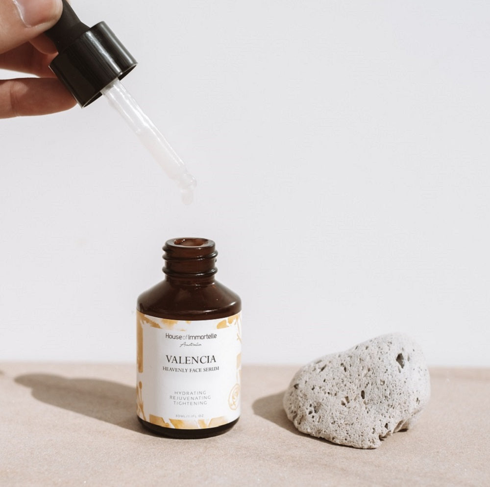 House of Immortelle Valencia Heavenly Face Serum in a sleek, elegant bottle, featuring a lightweight formula designed to hydrate and nourish the skin. The serum is infused with natural ingredients, offering a glowing, refreshed complexion, and is ideal for daily skincare routines